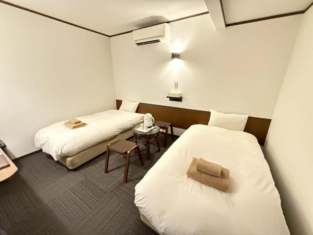 une chambre avec deux lits et une table avec un téléphone dans l'établissement Hakodate City - Hotel - Vacation STAY 40640v, à Naka-hamachō