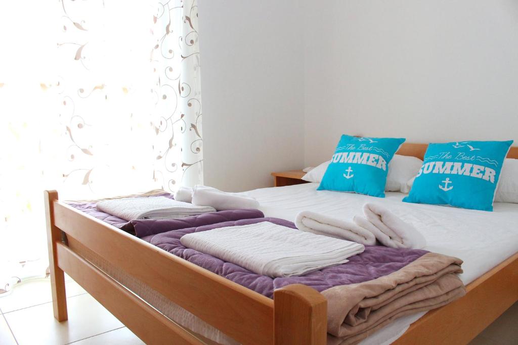a bed with blue and white pillows in a bedroom at Apartments Bella in Vodice