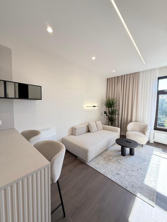 een witte woonkamer met een bank en een tafel bij FID B' Home, Studio moderne entre Vosges et vignoble in Guebwiller