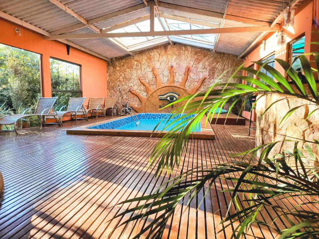 een zwembad in een kamer met een stenen muur bij Pousada Alfa e Ômega in Alto Paraíso de Goiás