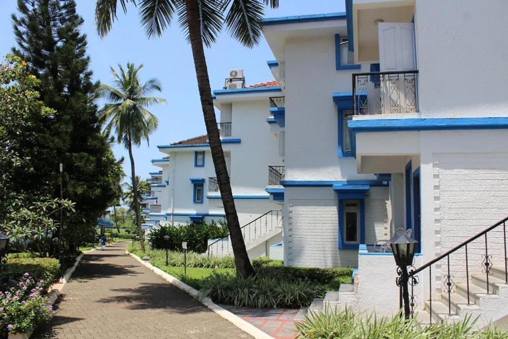 a building with a palm tree next to a street at The Beach comfort in Benaulim