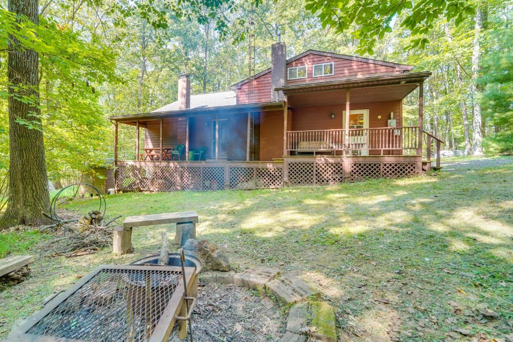 a house in the middle of a yard with trees at Cabin Comfort Near PSU! Fire Pit and On-Site Trails in Gatesburg
