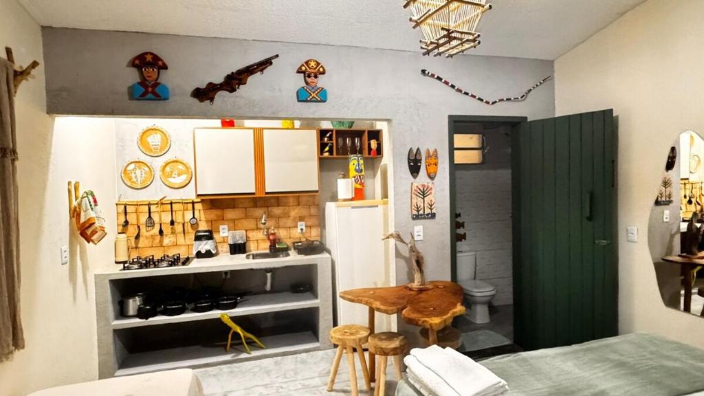 a kitchen with a table and a refrigerator at Kitnet Sertão na Ilha do Ferro AL in Pão de Açúcar