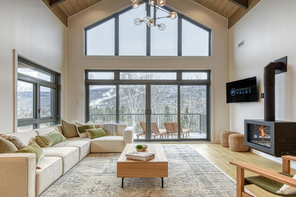 a living room with a couch and a fireplace at La Suite Evergreen at Verbier with Ski Golf and Luxury in Mont-Tremblant