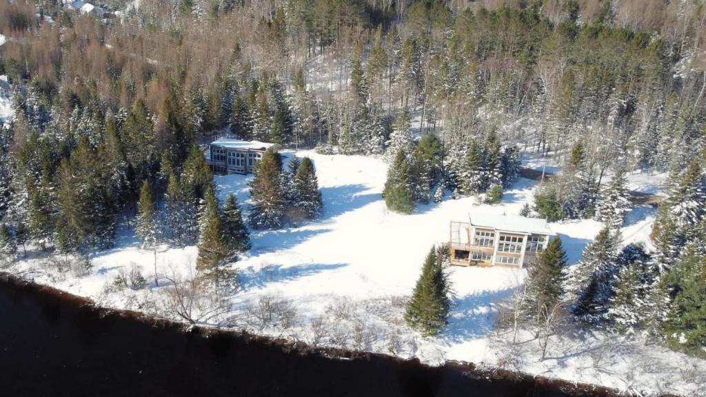 an aerial view of a house in the snow at Twin Cottages by the River - Corpo & Events in La Macaza