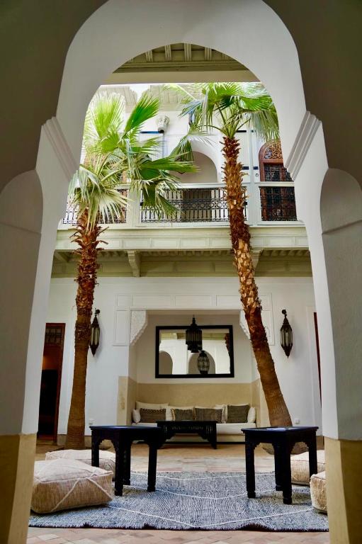 deux palmiers dans un salon avec une table dans l'établissement Riad Tzarra, à Marrakech 31 autres photos