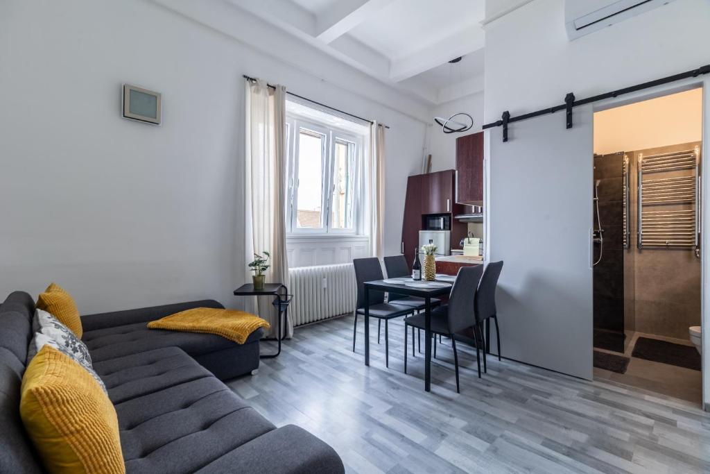 a living room and kitchen with a couch and a table at Budapest Panoramic Top-Floor Apartment with Citadella & Liberty Statue View in Budapest