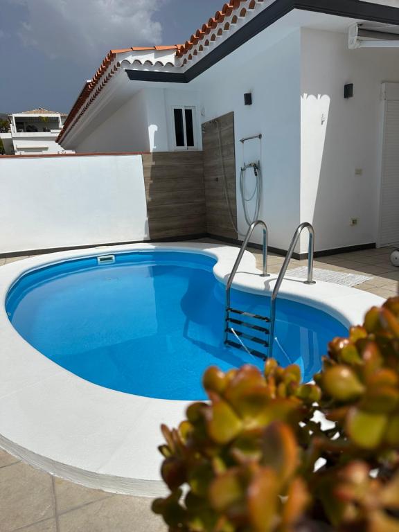 a swimming pool in front of a house at Villa Alexander in Puerto de Santiago
