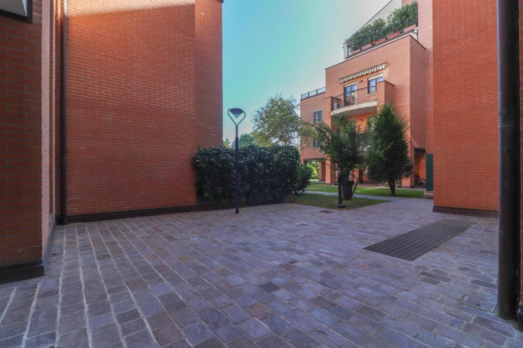 a courtyard with two tall brick buildings and a street at La casetta in Castel Maggiore