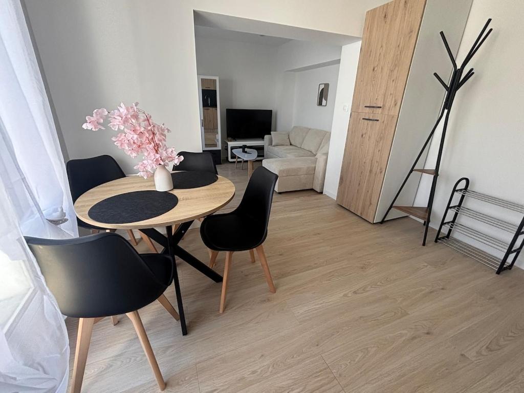ein Wohnzimmer mit einem Holztisch und Stühlen in der Unterkunft Studio confortable proche Lorient & Plages et voie express in Lanester