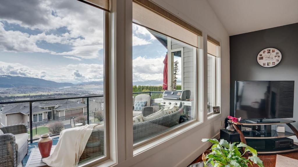 a room with a large window with a view at Hot Tub, Pool, City Views, close to Silver Star in Vernon