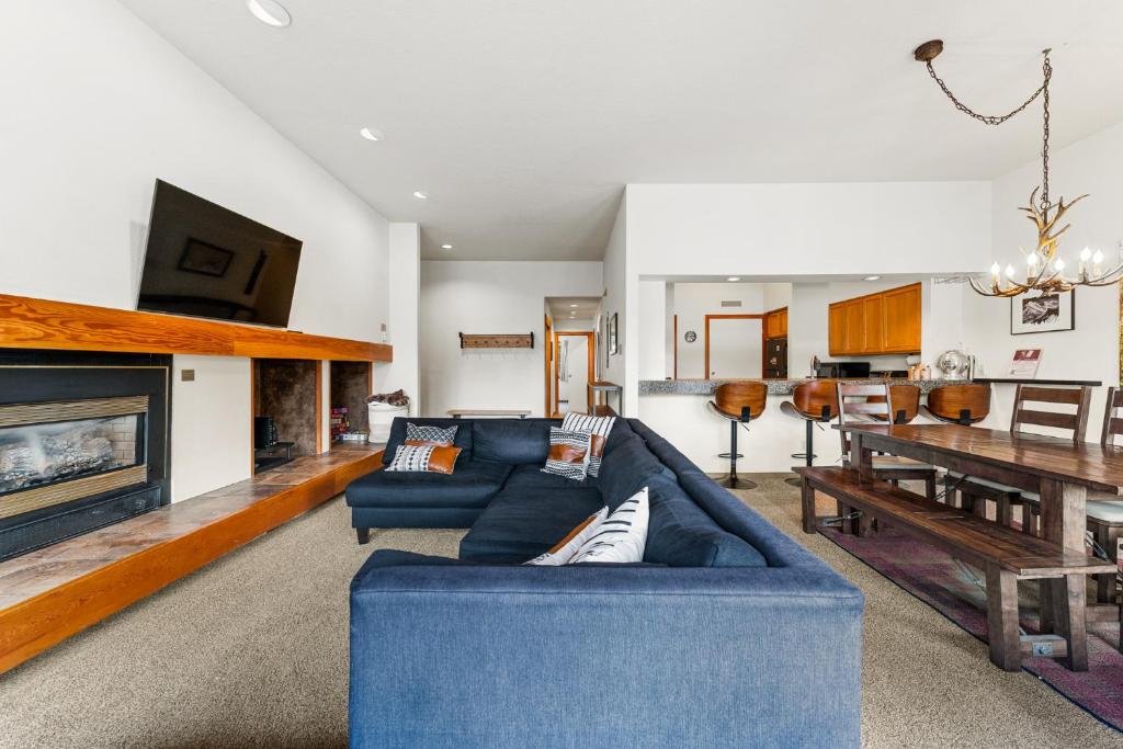 a living room with a blue couch and a table at Quicksilver 1645 by Summit County Mountain Retreats in Keystone