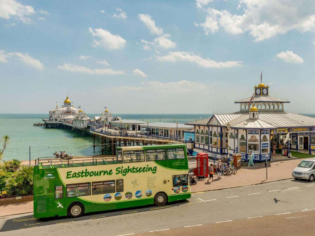 Un autobús verde de dos pisos estacionado junto a un muelle en 1 Bed in Eastbourne 88047, en Eastbourne