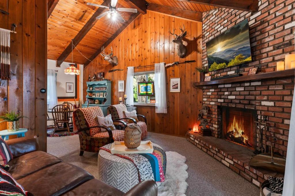 ein Wohnzimmer mit Kamin und Ziegelwand in der Unterkunft Retro Retreat, BBQ, Patio with Outdoor Seating! in Lake Arrowhead