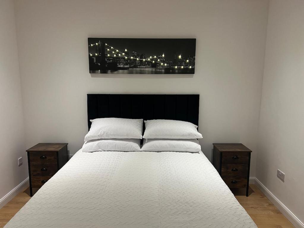 a bedroom with a white bed with two night stands at Lux & Cosy Private Apartment in Nuneaton in Nuneaton