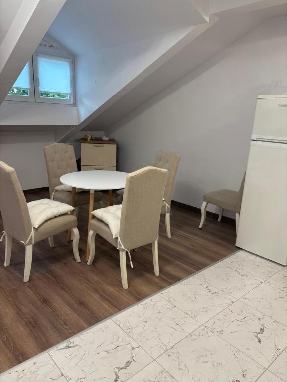 a dining room with a table and chairs and a refrigerator at White House Apartments - Studio Lux in Haskovo