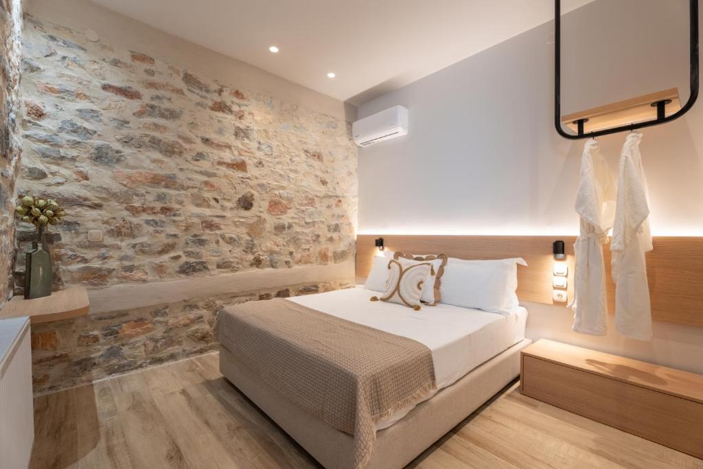 a bedroom with a stone wall and a bed at Nest in the City Studio Volos in Volos