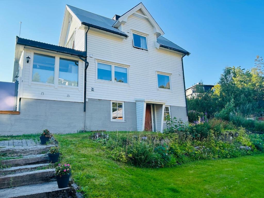 een wit huis met een tuin ervoor bij Koselig hus i Svolvær i Lofoten med elbil-lader in Svolvær