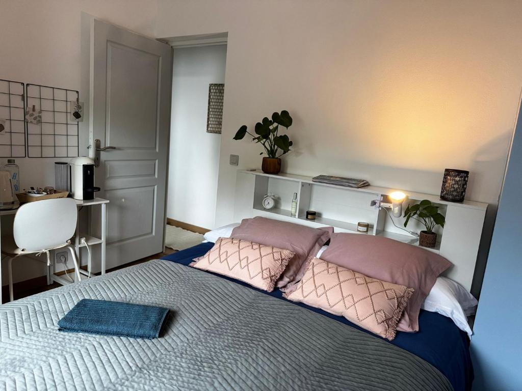 a bedroom with a large bed with pink pillows at Mi casa es tu casa in Orchies