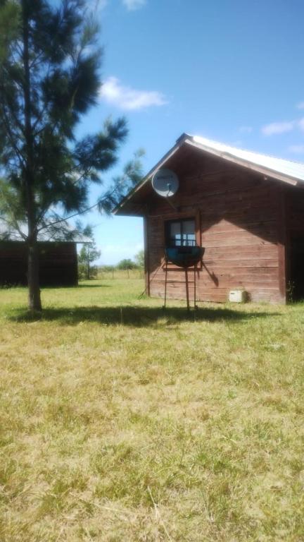 a log cabin with a frisbee in the window at Casa 1 Los Piamonteses 3 personas in Juan L. Lacaze