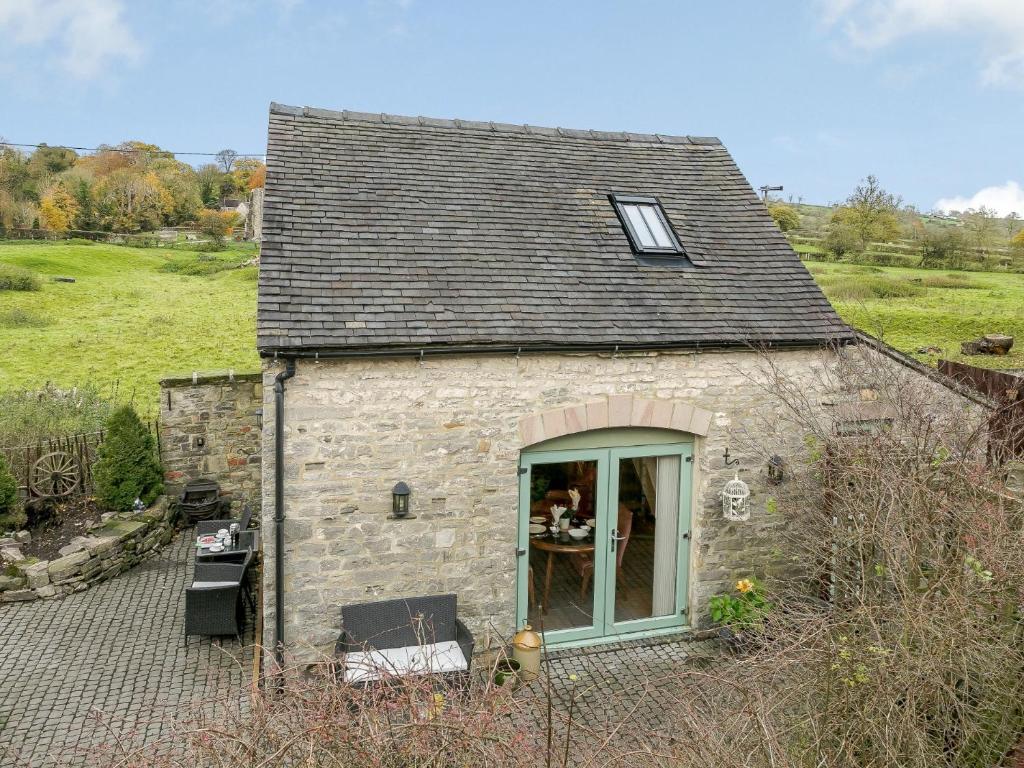 a small stone house with a window in a field at 1 Bed in Fenny Bentley 80376 in Fenny Bentley