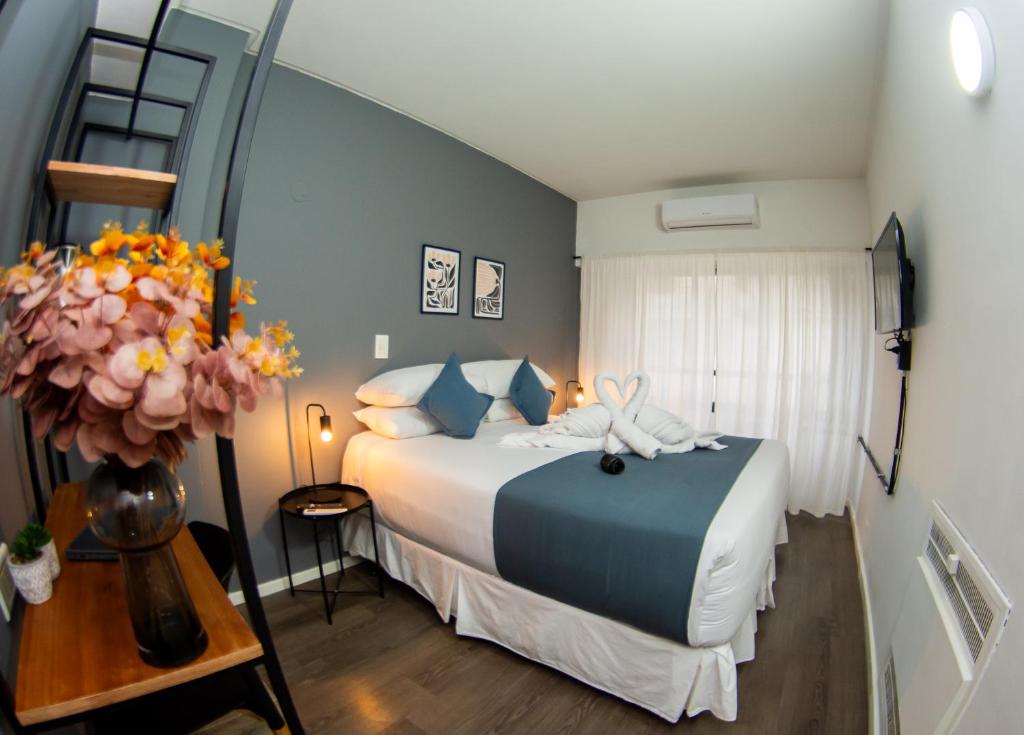 a bedroom with a bed and a vase of flowers at El Misti Suites Buenos Aires in Buenos Aires