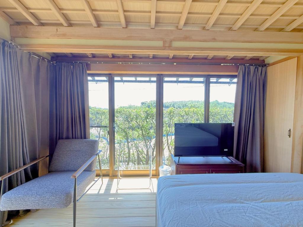 a bedroom with a bed and a tv and a window at Hot Spring Guest House Mikunien - Vacation STAY 18629v in Sakai