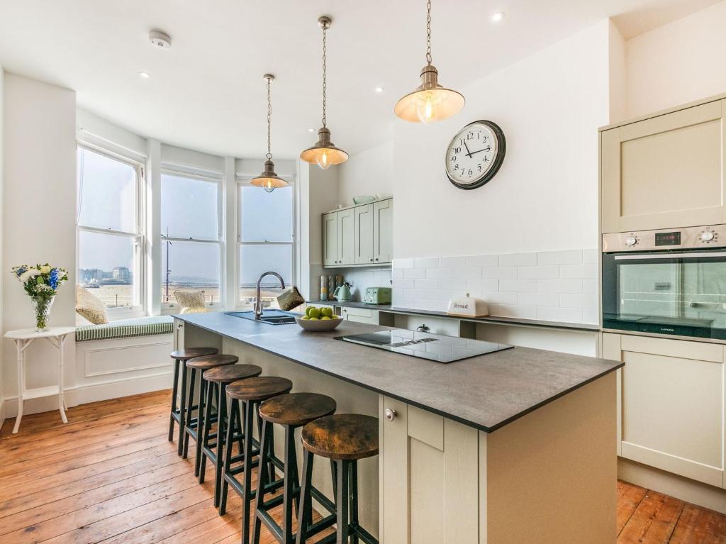マーゲイトにある5 bed property in Margate 86551のバースツール付きの大きな島のあるキッチンが備わります。