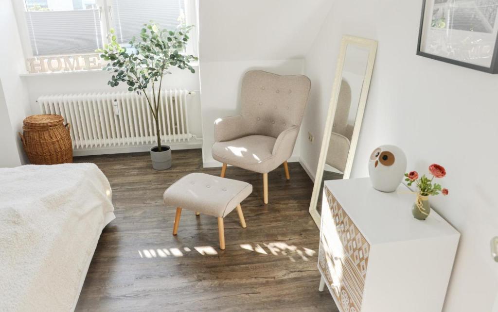 a living room with a chair and a mirror at 3 Zimmer Apartment zentral und ruhig - Nähe Autostadt, Parkplatz und WLAN - CityStay Wolfsburg - Beetle in Wolfsburg