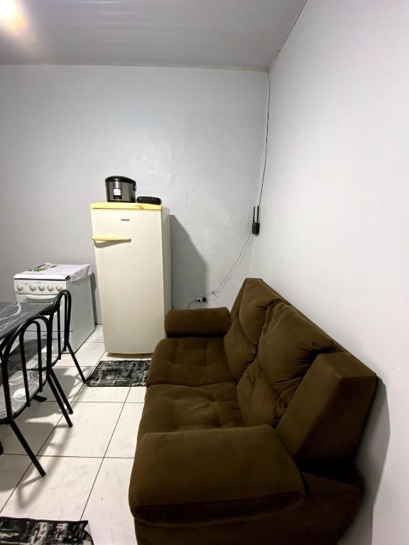 a living room with a couch and a refrigerator at Casa para 4 pessoas e garagem in Tangara da Serra