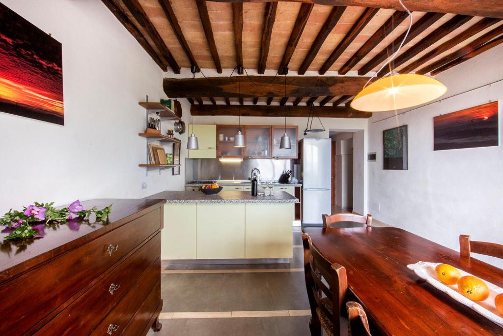 een keuken en eetkamer met een houten tafel bij Casa Burelli in Montalcino