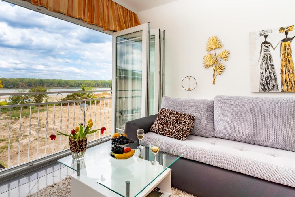 a living room with a couch and a glass table at Apartmani "A View to the Danube" in Vukovar