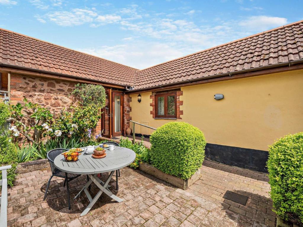 a patio with a table in the yard of a house at 1 Bed in Tiverton 53102 in Sampford Peverell