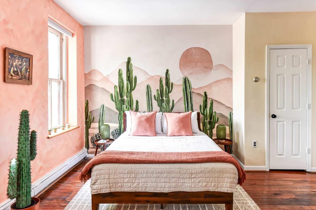 a bedroom with a bed with a cactus mural on the wall at 99 Walk Score half Block to King Western Studio in Alexandria