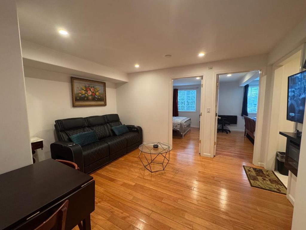 a living room with a black couch and a table at San Francisco 2 Bedroom with Parking near BART in San Francisco