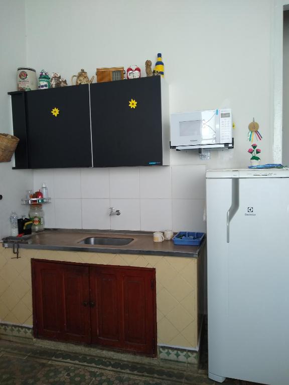 a kitchen with a sink and a refrigerator at Pousada Divino Espírito Santo in Paraisópolis