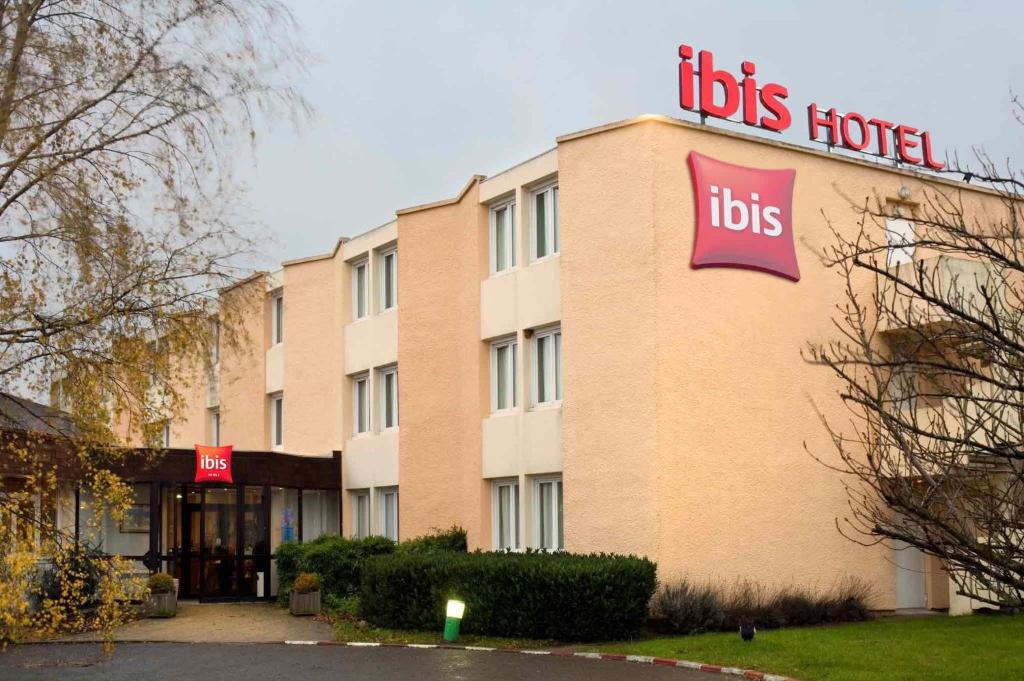 un hotel con un cartel en el lateral de un edificio en ibis Rambouillet, en Rambouillet