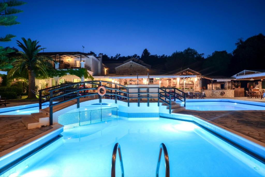 una piscina por la noche con un complejo en Paxos Club Resort & SPA en Gaios