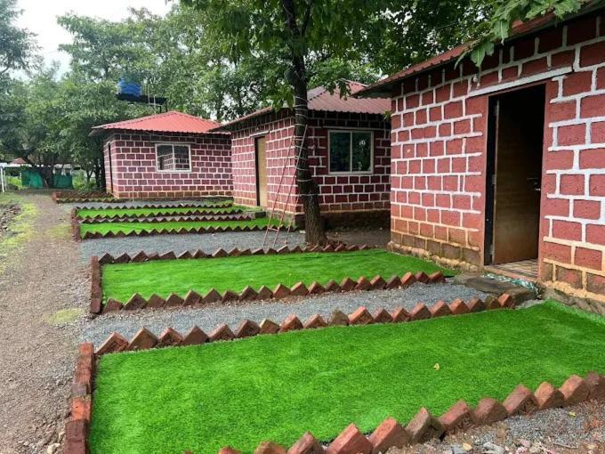 un edificio in mattoni con un cortile con erba verde di Heavenstone Resort a Pāli