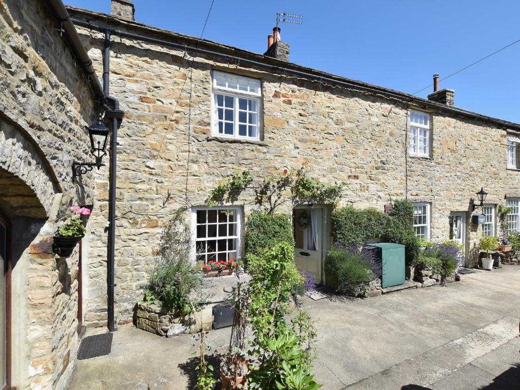 an old stone house with flowers in front of it at 1 Bed in Richmond 36769 in Reeth