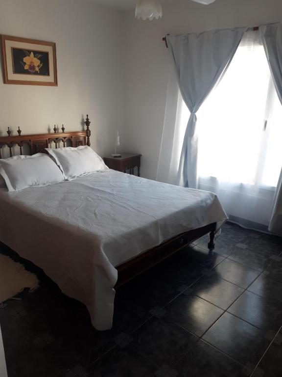 a bedroom with a large bed and a window at El Coco in Puerto Madryn