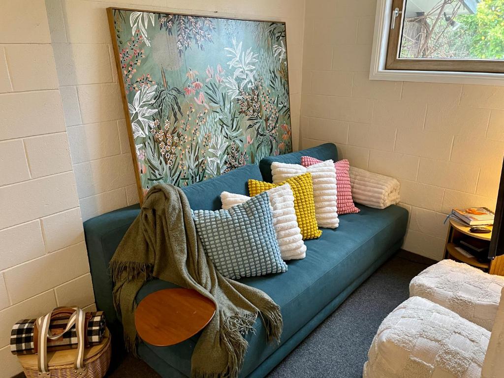 a blue couch with pillows on it in a room at White Rabbit Mountain Guest House in Mount Beauty
