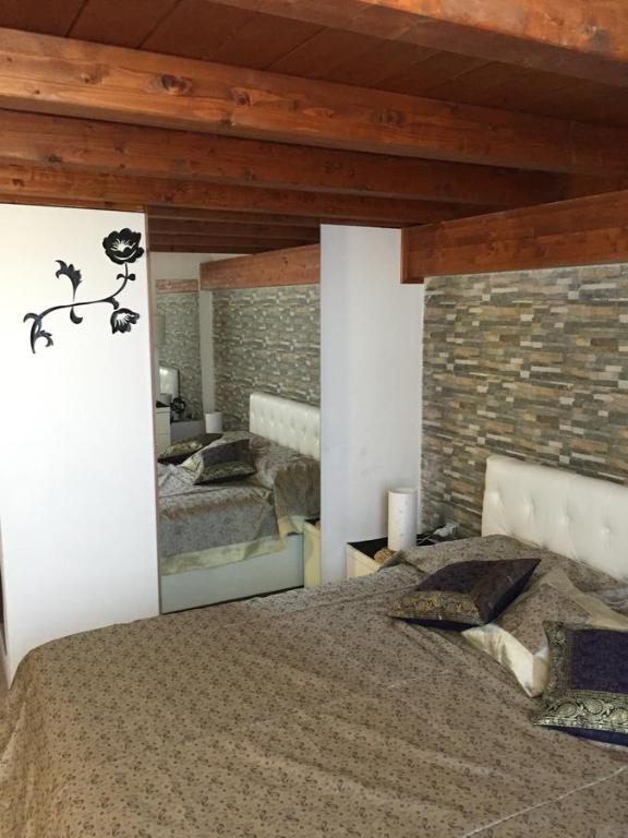 a bedroom with a bed and a brick wall at Bla Bla House Alghero-Olmedo in Olmedo