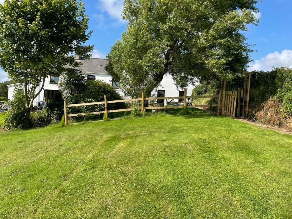a yard with a fence and a house at 2 Bed in Gower 62019 in Reynoldston