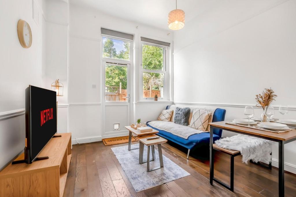 a living room with a couch and a tv at Modern 2BR Flat-Terrace-Free Parking-Rail Station in Croydon