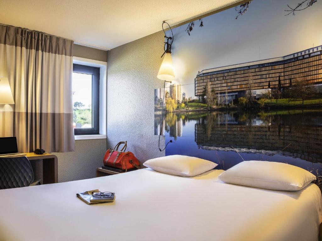 una habitación de hotel con una cama con una pintura en la pared en ibis Paris Creteil, en Créteil