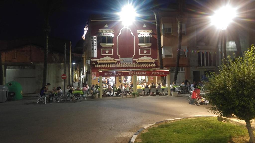 a group of people sitting outside a restaurant at night at Hostal Rosaleda in Alcalà de Xivert