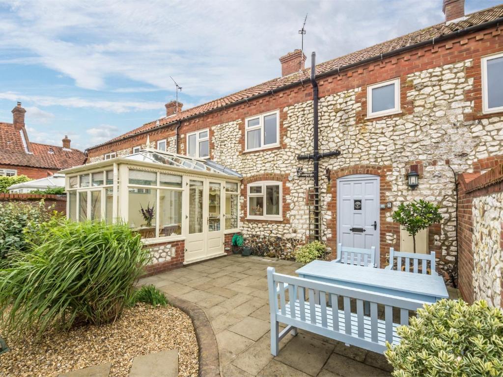 an exterior view of a brick house with a bench at 3 Bed in Thornham KT111 in Thornham