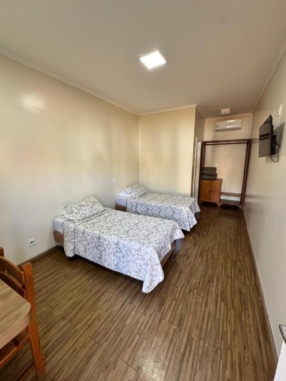 a room with two beds and a tv in it at Cravinhos Park Hotel in Cravinhos