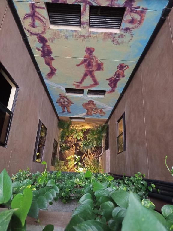 a painting on the ceiling of a building with plants at hotel civitas medellin in Medellín